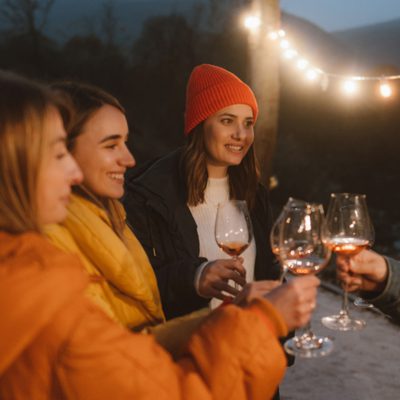 Photo of female friends drinking wine during an outdoor dinner party
