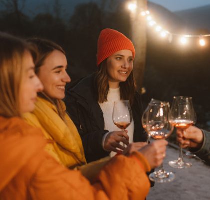 Photo of female friends drinking wine during an outdoor dinner party