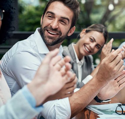 Shot of a group of colleagues applauding during a meeting at a cafe