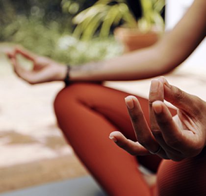 Woman, mudra hands and meditation for wellness, freedom and calm chakra energy in garden, park and zen. Closeup girl, yoga exercise and meditate in lotus outdoors for mental health, hope and mindset